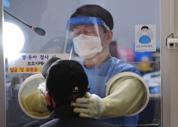 안철수 국민의당 대선후보가 설 연휴 마지막 날인 2일 서울 중구보건소 선별진료소에서 코로나19 검체 채취 의료봉사 활동을 하고 있다. 이날 동행한 딸 안설희 박사는 행정 업무 등을 지원했다. 2022.2.2/뉴스1 © News1 오대일 기자