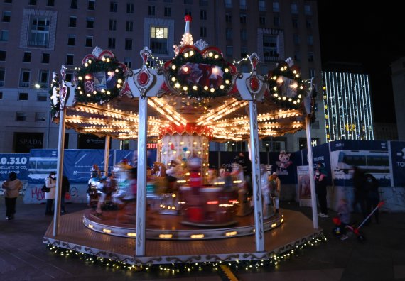 [밀라노(이탈리아)=신화/뉴시스] 지난달 6일(현지시간) 이탈리아 밀라노에서 시민들이 회전목마를 타고 있다. 2022.02.03.