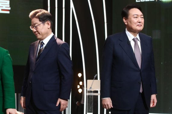 3일 오후 서울 여의도 KBS 공개홀에서 열린 2022 대선후보 토론에서 이재명 더불어민주당 대선 후보가 기념촬영을 마친 뒤 자리로 돌아가고 있다. 오른쪽은 윤석열 국민의힘 대선 후보. 2022.2.3/뉴스1, 국회사진취재단