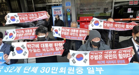 [서울=뉴시스] 최진석 기자 = 박근혜 서포터즈 중앙회 등 보수진영 애국 단체 일부 회원들이 4일 서울 여의도 더불어민주당 중앙당사 앞에서 이재명 더불어민주당 대선 후보 지지하며 펼침막을 들고 있다. 2022.02.04. myjs@newsis.com