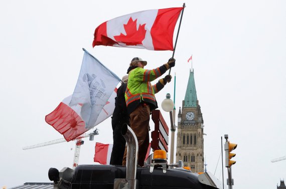 캐나다 정부의 코로나19 방역대책에 반대하는 트럭 시위대가 캐나다 국회의사당 바로 앞에 트럭을 정차시켜놓고 그 위에서 캐나다 깃발을 흔들고 있다. /사진=로이터뉴스1