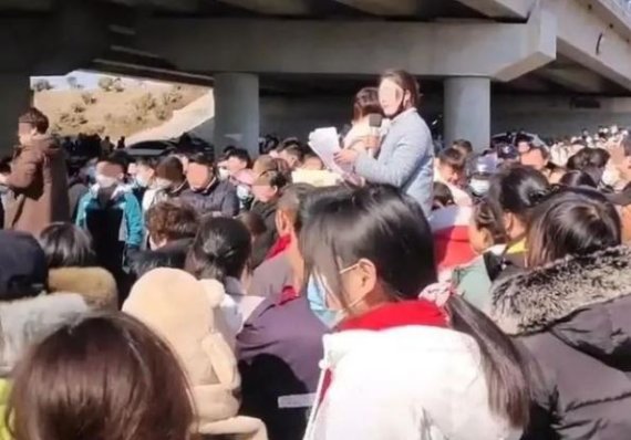 지난 5일 중국 장쑤성 쉬저우의 현급시인 피저우시 다리 밑 공터에 마련된 소개팅 장소에서 한 여성이 종이에 적힌 글을 읽고 있다. 중국 매체 캡쳐.