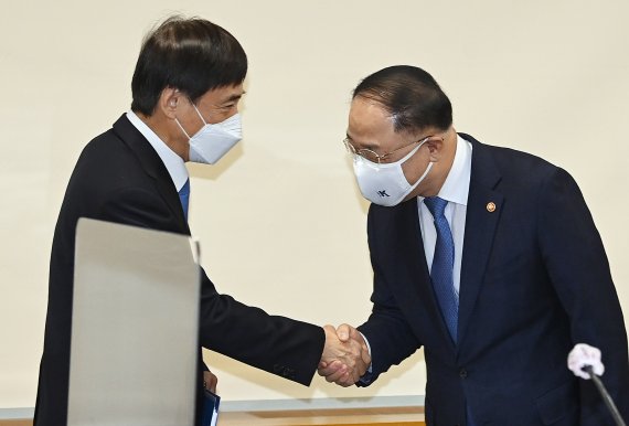 홍남기 부총리와 이주열 한국은행 총재가 '확대 거시경제금융회의'에서 인사를 나누고 있다.