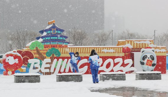 2022 베이징 동계올림픽 개막 후 첫 눈이 내리는 13일 중국 베이징 메인미디어센터 앞 공원에서 자원봉사자들이 기념촬영을 하고 있다. 2022.2.13/뉴스1 © News1 안은나 기자