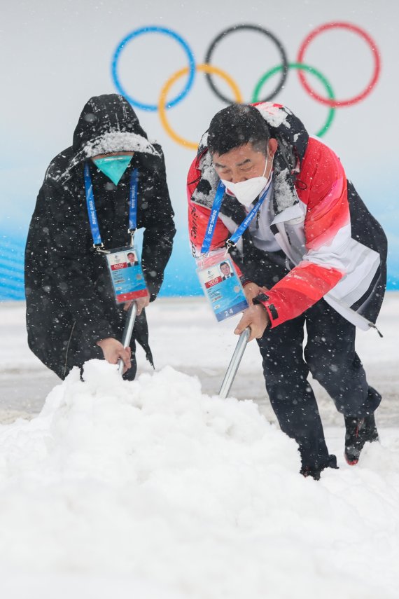 2022 베이징 동계올림픽 개막 후 첫 눈이 내리는 13일 컬링 경기장인 중국 베이징 국립아쿠아틱센터에서 관계자들이 제설작업을 하고 있다. 2022.2.13/뉴스1 © News1 안은나 기자