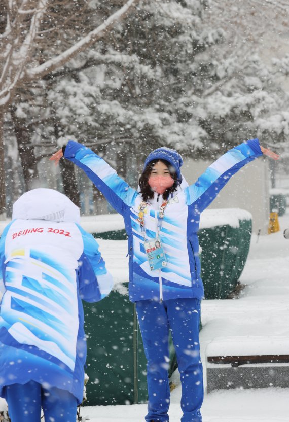 2022 베이징 동계올림픽 개막 후 첫 눈이 내리는 13일 중국 베이징 메인미디어센터 앞 공원에서 관계자들이 기념촬영을 하고 있다. 2022.2.13/뉴스1 © News1 안은나 기자
