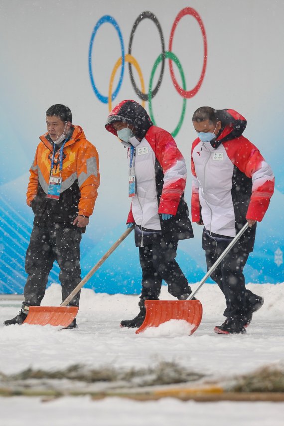 2022 베이징 동계올림픽 개막 후 첫 눈이 내리는 13일 중국 베이징 국립아쿠아틱센터에서 관계자들이 제설작업을 하고 있다. 2022.2.13/뉴스1 © News1 안은나 기자