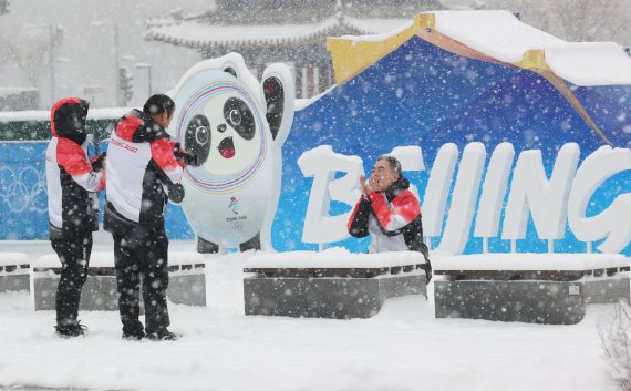 2022 베이징 동계올림픽 개막 후 첫 눈이 내리는 13일 중국 베이징 메인미디어센터 앞 공원에서 관계자들이 기념촬영을 하고 있다. 2022.2.13/뉴스1 © News1 안은나 기자