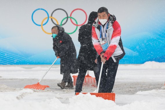 2022 베이징 동계올림픽 개막 후 첫 눈이 내리는 13일 컬링 경기장인 중국 베이징 국립아쿠아틱센터에서 관계자들이 제설작업을 하고 있다. 2022.2.13/뉴스1 © News1 안은나 기자