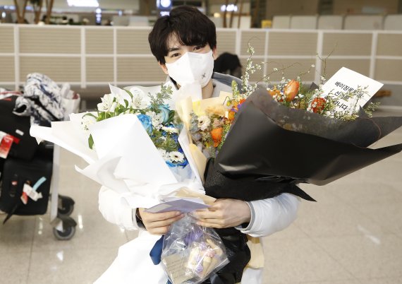 피겨 스케이팅 선수 차준환(21·고려대)이 2022 베이징 동계올림픽 공식 경기 일정을 마치고 13일 오후 인천국제공항을 통해 입국해 꽃다발을 선물받고 있다. 2022.2.13/뉴스1 © News1 권현진 기자