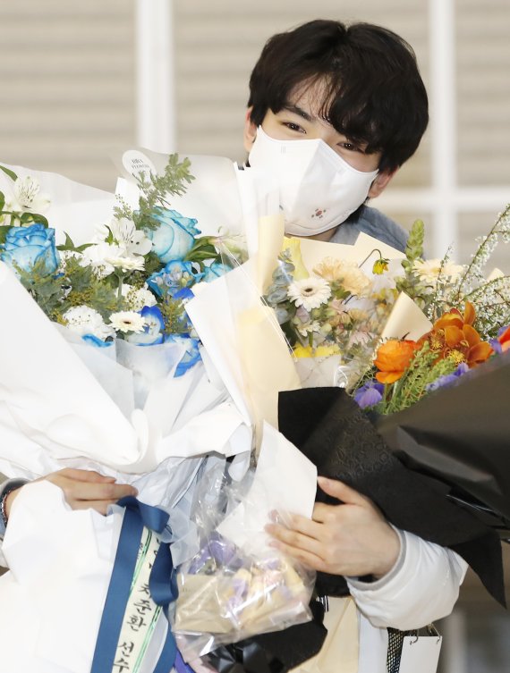 피겨 스케이팅 선수 차준환(21·고려대)이 2022 베이징 동계올림픽 공식 경기 일정을 마치고 13일 오후 인천국제공항을 통해 입국해 꽃다발을 선물 받은뒤 행복한 미소를 짓고 있다. © News1 권현진 기자