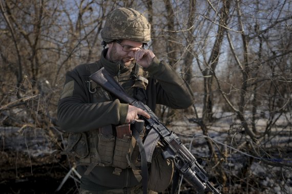우크라이나 동부 루한스크 포파나야(Popasna) 외곽에서 14일(현지시간) 경계근무를 서던 우크라이나 병사가 안경을 고쳐 쓰고 있다. 우크라이나에 전운이 짙어지는 가운데 미국은 이날 키예프 대사관을 서부 리비우로 이동한다고 밝혔다. AP뉴시스