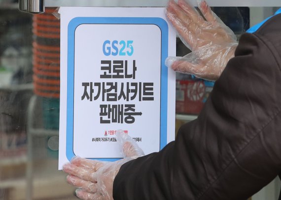 [서울=뉴시스] 권창회 기자 = 15일 오후 서울 서대문구 GS25 연대2점에서 관계자가 코로나19 자가검사키트 판매 안내문을 붙이고 있다. 오늘부터 내달 5일까지 대용량 포장으로 공급되는 코로나19 자가검사키트를 약국·편의점에서 낱개로 나눠 판매할 시 개당 6000원에 판매한다. 기간은 모니터링 결과에 따라 변동될 수 있다. 2022.02.15. kch0523@newsis.com