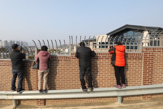 박근혜 전 대통령이 퇴원 후 정치적 고향인 대구에서 생활하기 위해 달성군 유가읍 쌍계리의 한 주택을 본인 명의로 매입한 사실이 알려진 가운데 13일 사저를 구경하려는 시민들이 건물 뒤편 가드레일 위에 올라가 담장 안을 살펴보고 있다. 2022.2.13/뉴스1 © News1 공정식 기자