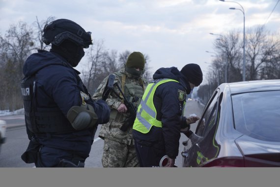 우크라이나 군인들이 17일(현지시간) 보안국 직원들과 함께 북동부 지역 접경지대인 하르키우(Kharkiv)에서 도로를 막고 검문하고 있다. 우크라이나 위기가 재고조되면서 이날 금융시장은 크게 흔들렸다. AP뉴시스