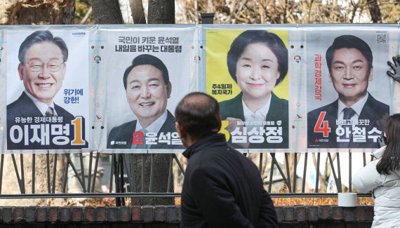 [서울=뉴시스] 권창회 기자 = 종로구 선거관리위원회 직원들이 18일 오후 서울 종로구 이화동 예술가의 집 울타리에서 제20대 대통령 선거 후보자들의 선거 벽보를 첩부하고 있다. 2022.02.18. kch0523@newsis.com /사진=뉴시스