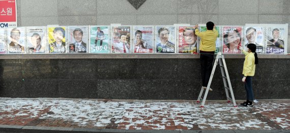 [광주=뉴시스] 류형근 기자 = 18일 오후 광주 북구 운암동 모 아파트 벽에 운암1동행정복지센터 직원들이 제20대 대통령선거 후보자들의 '선거벽보'를 부착하고 있다. 2022.02.18. hgryu77@newsis.com