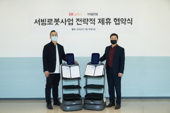 지난 18일 서울 문정동 가든파이브에서 SK쉴더스 김윤호 전략사업그룹장(오른쪽)과 우아한형제들 김민수 서빙로봇실장이 '서빙 로봇 사업 전략적 제휴 업무협약'을 체결한 뒤 기념촬영을 하고 있다. SK쉴더스 제공