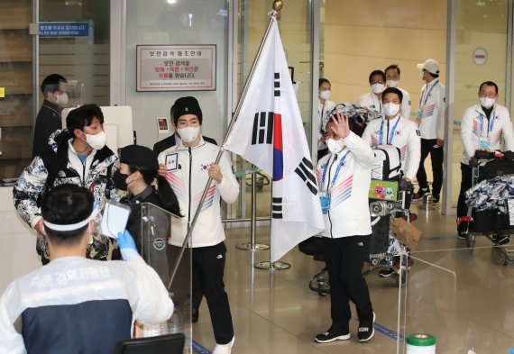 [인천공항=뉴시스] 조수정 기자 = 2022 베이징 동계올림픽에 출전했던 대한민국 선수단이 21일 오후 인천국제공항 제2터미널을 통해 귀국, 입국장에서 열린 환영행사장으로 향하고 있다. 태극기를 든 이는 스피드 스케이팅 차민규. 2022.02.21. chocrystal@newsis.com