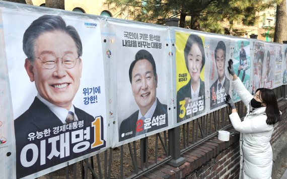 선관위 직원이 서울 종로구 이화동 예술가의집 울타리에 '제20대 대통령선거'에 출마하는 후보자들의 선거벽보를 붙이고 있다. 2022.2.18/뉴스1 © News1 임세영 기자 /사진=뉴스1