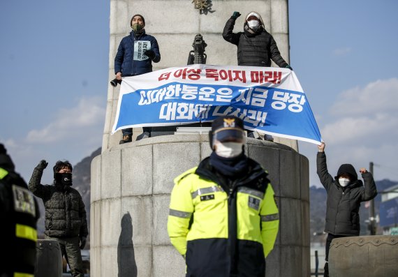 CJ대한통운 택배노동자들이 22일 오후 서울 종로구 이순신동상 위에서 CJ대한통운에 대화를 촉구하며 기습시위를 하고 있다.<div id='ad_body2' class='ad_center'></div><div id='ad_body3' class='mbad_bottom' ></div> /사진=뉴시스