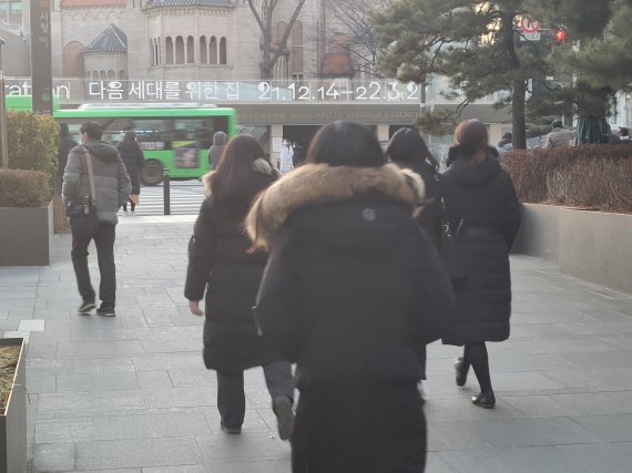 서울 시청역 앞에서 퇴근하는 청년 직장인들 사이로 '다음 세대를 위한 집'이라는 문구가 보이고 있다. 사진=김희수 기자