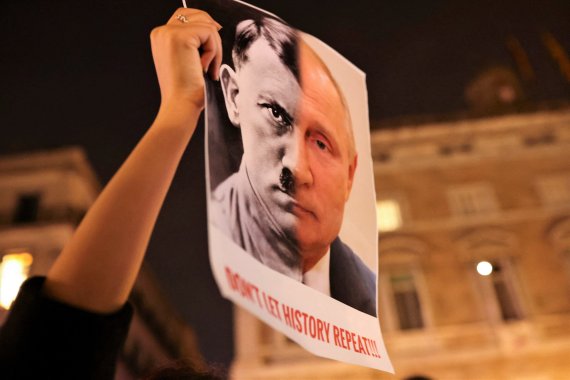 스페인 바르셀로나에서 24일(현지시간) 한 시민이 히틀러와 푸틴이 합성된 이미지를 들고 반전 시위를 벌이고 있다. 로이터뉴스1