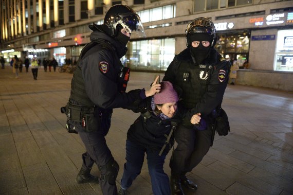 25일(현지시간) 러시아 경찰이 모스크바에서 한 여성을 연행하고 있다. 러시아인들은 소셜미디어 등을 통해 러시아의 우크라이나 침공을 비난하며 시위를 촉구했다. 러시아 54개 도시에서 크고 작은 시위가 일어나 약 1800명이 체포됐고 그중 약 1천 명은 모스크바에서 체포됐다.사진=뉴시스