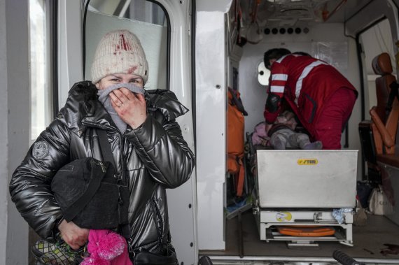 우크라이나 동부 마리우폴에서 지난 2월27일(현지시간) 구급대원이 러시아군의 포격으로 부상당한 6세 소녀를 지켜보며 한 여성이 울음을 터뜨리고 있다. 뉴시스/AP /사진=뉴시스 외신화상