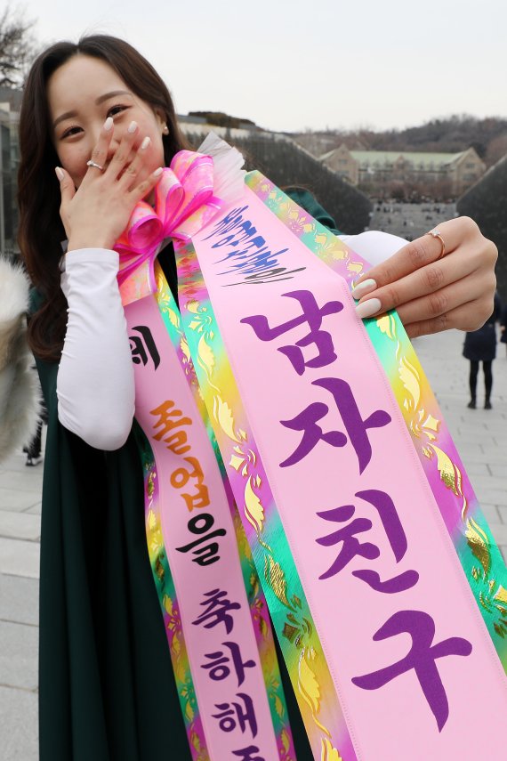 [서울=뉴시스] 백동현 기자 = 이화여대 20221학년도 전기 학위수여식이 개최된 28일 오후 서울 서대문구 이화여자대학교에서 한 졸업생이 '졸업선물은 남자친구'라는 문구를 목에 걸고 있다. 2022.02.28. livertrent@newsis.com