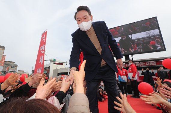 [강릉=뉴시스] 전신 기자 = 윤석열 국민의힘 대선 후보가 28일 강원도 강릉 월화거리 광장에서 열린 유세에서 시민들과 인사하고 있다. 2022.02.28. photo1006@newsis.com