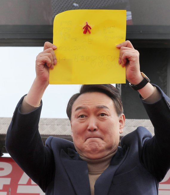 [강릉=뉴시스] 전신 기자 = 윤석열 국민의힘 대선 후보가 28일 강원도 강릉 월화거리 광장에서 열린 유세에서 한 아이가 건넨 편지를 들어보이고 있다. 2022.02.28. photo1006@newsis.com