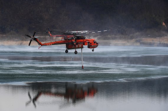[합천=뉴시스] 차용현 기자 = 지난 28일 경남 합천군에서 발생한 산불이 경북 고령군 쌍림면까지 번진 가운데 1일 오전 합천군 핫들생태공원 인근 강에서 산림청 소속 산불진화헬기가 물을 채우고 있다 2022.03.01. con@newsis.com