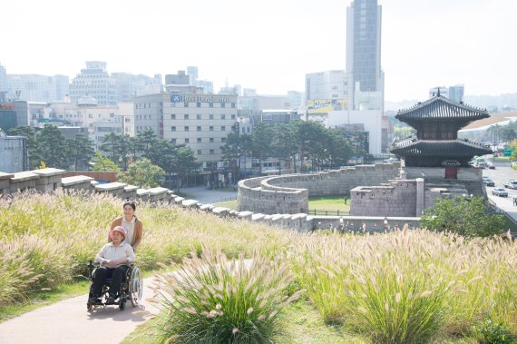 수전동 휠체어로 오르막길을 힘들이지 않고 오르고 있다.서울관광재단 제공
