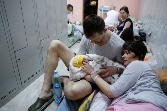 우크라이나 키이우의 한 산부인과 병원 지하 대피소에서 한 부부가 갓 태어난 아기를 보고 있다. © 로이터=뉴스1
