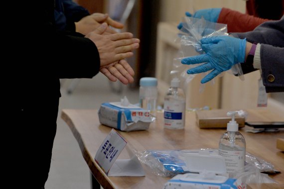 [광주=뉴시스] 변재훈 기자 = 제20대 대통령 선거 사전투표 첫날인 4일 오전 광주 광산구 첨단1동 투표소 앞에서 한 유권자가 코로나19 예방을 위해 손 소독을 하고 있다. 2022.03.04. wisdom21@newsis.com