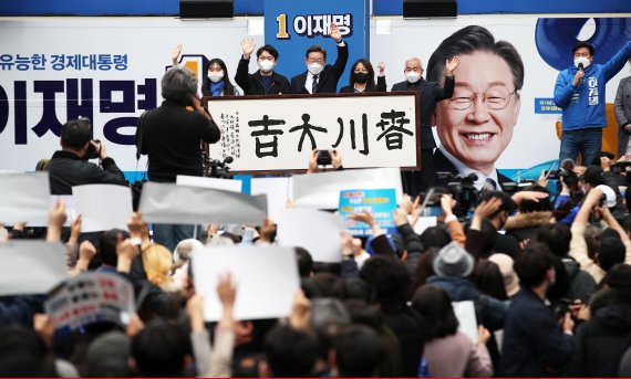 이재명 더불어민주당 대선 후보가 20대 대선 사전투표가 시작된 4일 오후 강원 춘천시 브라운5번가 앞에서 열린 '새로운 춘천 시대, 이재명은 합니다!' 춘천 집중유세에서 '춘천대길' 붓글씨를 전달받은 후 인사하고 있다. 2022.3.4/뉴스1 © News1 오대일 기자