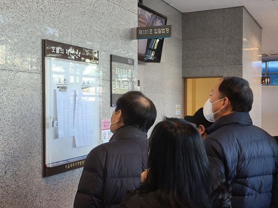 서울북부지방법원 경매법정 앞에서 입찰 참여자들이 매물 명단을 확인하고 있다. 사진=김희수 기자