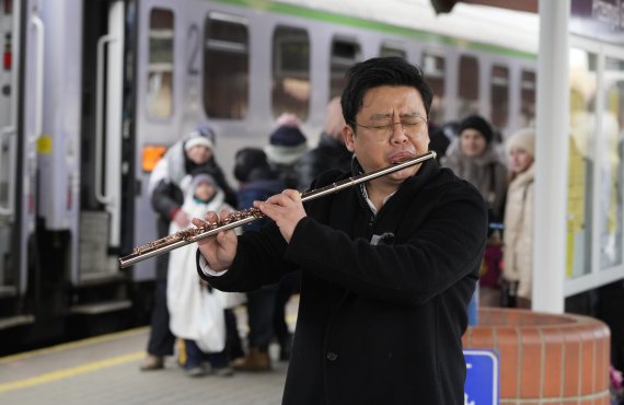 한국인으로 추정되는 한 남성이 7일(현지시간) 폴란드 동남부의 프셰미실 기차역에서 우크라이나 피난민들을 위해 플루트로 한국 전통음악을 연주하고 있다. AP뉴시스
