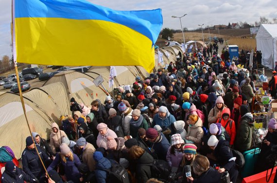 8일(현지시간) 우크라이나와 접한 폴란드의 국경 검문소에서 우크라이나 난민들이 이동용 버스를 기다리고 있다.로이터뉴스1