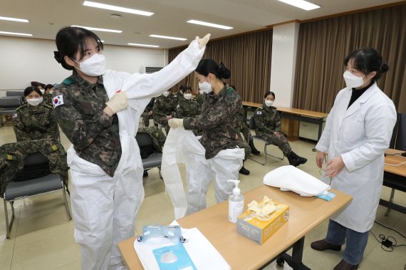 [서울=뉴시스] 이윤청 기자 = 국군간호사관학교 3학년 생도들이 18일 충남지역 생활치료센터에서 코로나19 추가 확산을 차단하기 위한 범정부적 대응 지원대책에 따른 간호 임무 수행을 위해 개인보호구 착용법 교육을 받고 있다. 2020.12.18. (사진=국방부 제공) photo@newsis.com
