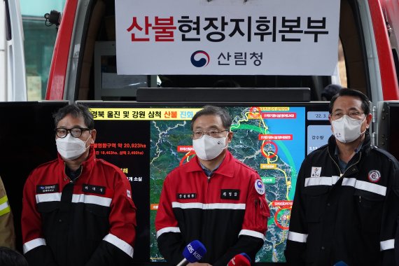최병암 산림청장이 13일 경북 울진군 죽변면 산불현장통합지휘본부에서 유관기관 관계자들과 경북 울진 및 강원 삼척 주불 진화 완료 선언을 하고 있다. (산림청 제공) 2022.3.13/뉴스1