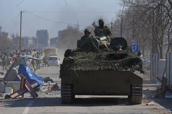 소속을 나타내는 휘장을 부착하지 않은 군복을 입은 친러시아계 병력이 19일(현지시간) 우크라이나 남부 항구도시 마리우폴 거리를 장갑차를 타고 이동하고 있다. 3주를 버티던 마리우폴에서는 현재 시가전이 벌어지고 있다. 로이터뉴스1