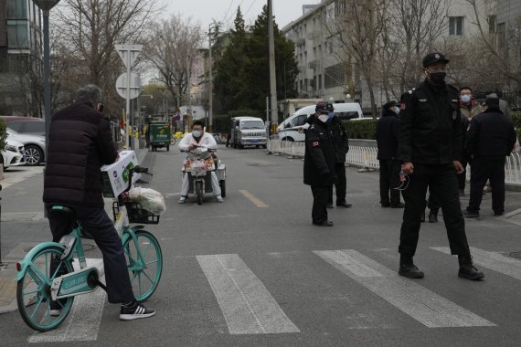 [베이징=AP/뉴시스] 17일 중국 베이징에서 중국 보안요원들이 봉쇄 구역과 연결된 도로를 차단하고 출입을 막고 있다. 중국의 코로나19 확진자가 급증하는 가운데 시진핑 국가주석은 "버티는 것이 곧 승리"라며 '제로 코로나' 정책 유지를 강조했다. 2022.03.18.