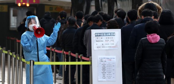 21일 오전 서울 태평로 서울광장 임시선별검사소에서 의료진이 길게 줄 선 시민들에게 코로나19 검사 안내를 하고 있다. 뉴시스 제공