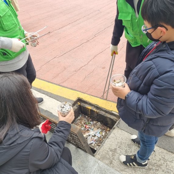 영도희망공동체 학생들이 20일 오후 영도 인근 지역에서 담배꽁초 수거 활동을 하고 있다.(영도희망공동체 제공)© 뉴스1