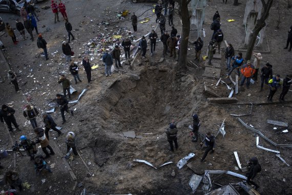 20일(현지시간) 우크라이나 키이우에서 주민들이 폭탄 구덩이 주변에 모여 있다. 사진=뉴시스