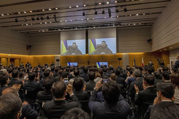 23일 오후 일본 도쿄 중의원 회관에서 일본 국회 의원들이 볼로디미르 젤렌스키 우크라이나 대통령의 화상 연설을 지켜보고 있다. 휴대전화로 사진을 찍거나, 박수를 치는 사람들이 보인다. AP뉴시스