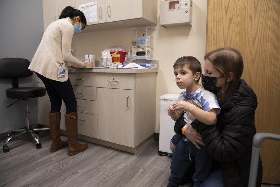 미국 뉴요 코맥의 모더나 코로나19 백신 임상시험 센터에서 지난해 11월 30일(현지시간) 세 살 박이 아동이 엄망와 함께 임상시험 예약을 하고 있다. AP뉴시스