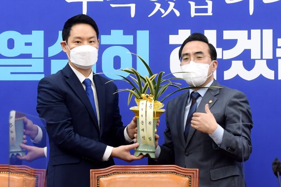 박홍근 더불어민주당 신임 원내대표(오른쪽)가 25일 오전 서울 여의도 국회에서 김한규 대통령비서실 정무비서관에게 문재인 대통령의 축하 난을 받고 감사 인사를 전하고 있다. 2022.3.25/뉴스1 © News1 이동해 기자